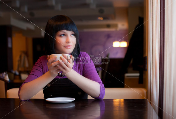 girl hold cup of coffee in hand look in window
