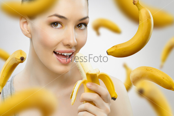 Молодая девушка и летающие бананы на белом фоне