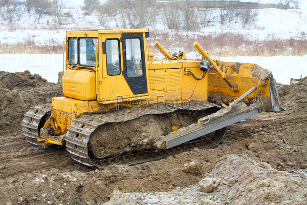 bulldozer loader at winter frozen soil excavation works
