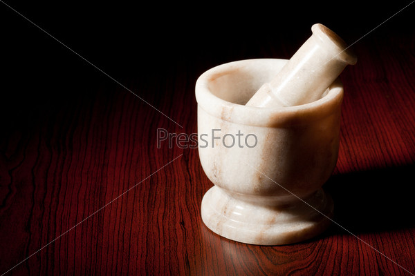 Marble mortar and pestle on dark wood background, stock photo