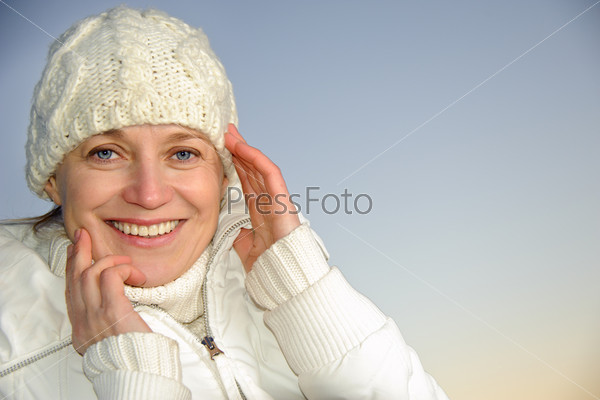 Blue-eyed woman in white on the blue sky background. winter.