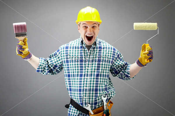 Мастер в строительной каске и с инструментами в руках громко кричит