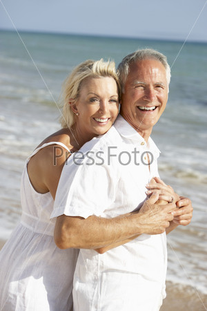Senior Couple Enjoying Beach Holiday In The Sun