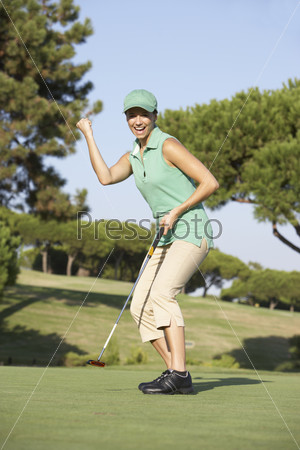 Female Golfer On Golf Course Putting On Green