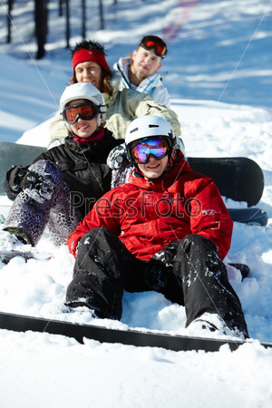 Portrait of happy friends snowboarding during winter vacations