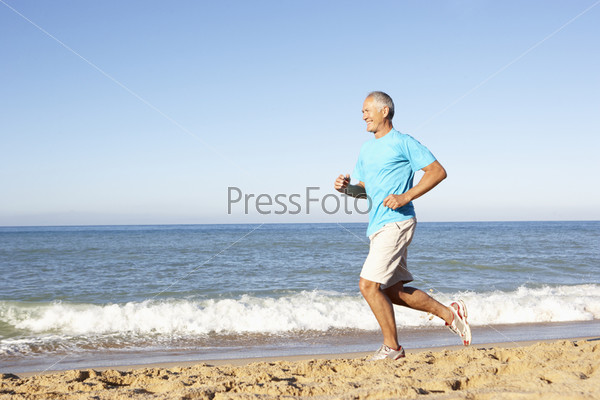 Senior Man In Fitness Clothing Running Along Beach