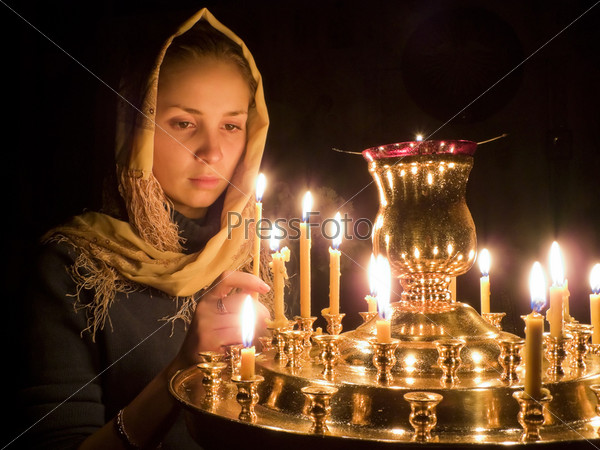 Girl with a candle in the Orthodox Church.