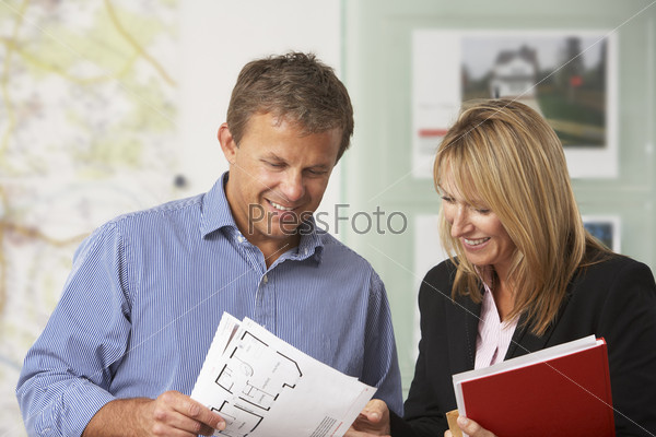 Female Estate Discussing Property Details With Client
