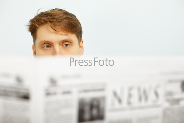A young man reads the news in the newspaper