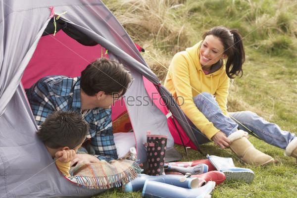 Young Family Relaxing Inside Tent On Camping Holiday, stock photo