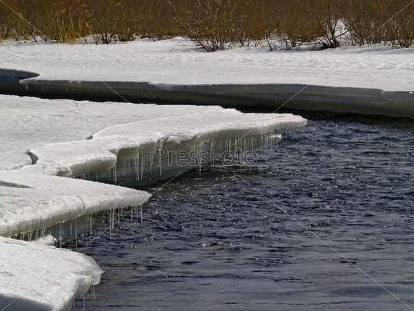 Талый лед на берегу реки