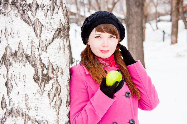 beautiful  woman  near a birch with a green apple in hands