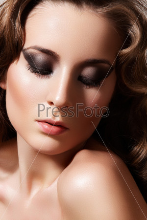 Beautiful face of young woman with clean skin. Girl with long curly hairs