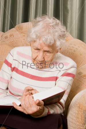 The elderly woman reads the book