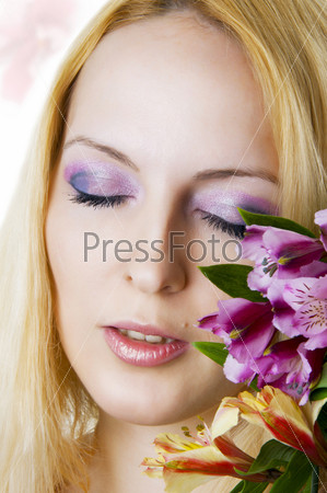 Female face with healthy skin and closed eyes  closeup, creative makeup  and spring flowers. Skincare, spa and floral concept.