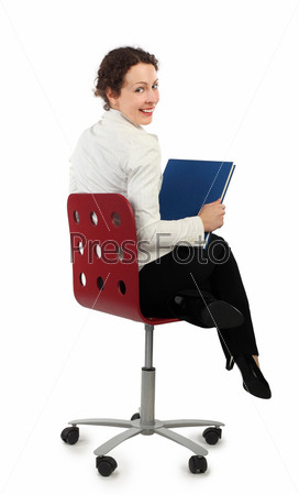 young attractive woman in business dress sitting on chair and holding a book, view from back, isolated on white