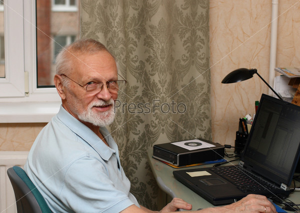 working senior with laptop computer at home
