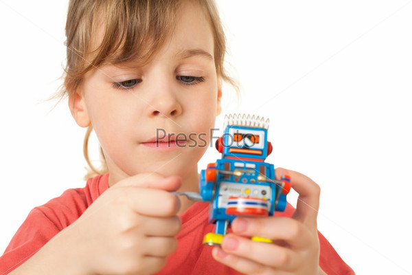 Girl in red T-shirt plays with clockwork robot