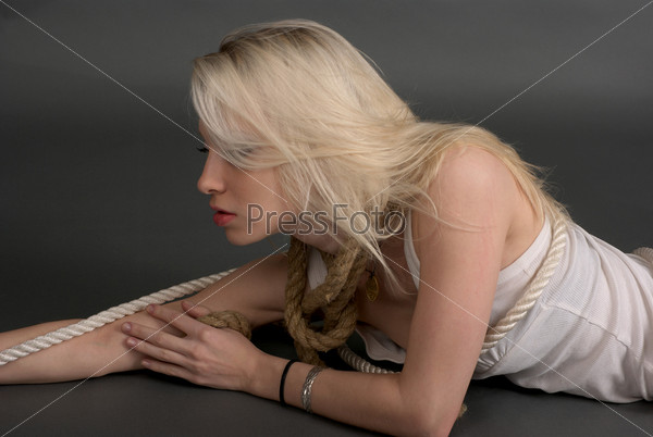 Cute young woman twisted with ropes
