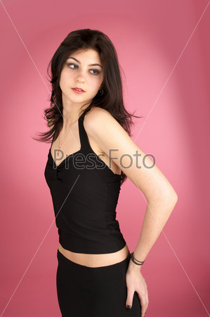 Beautiful elegant woman fits on clothes over pink background.