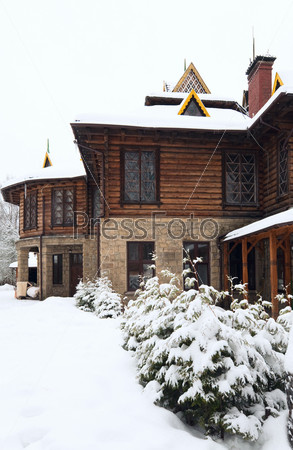 country wooden house and winter fir trees
