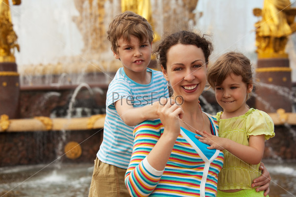Мама с детьми у фонтана в летний день