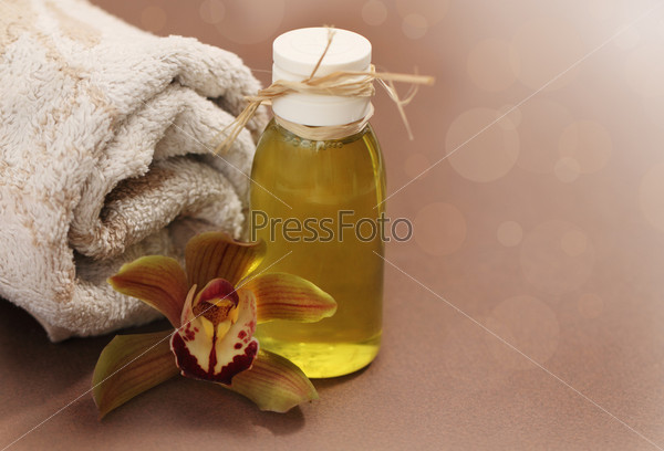Spa setting with orchid, towel and massage oil
