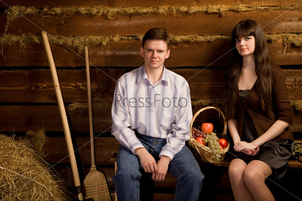 Man and woman near basket of fruit on bench