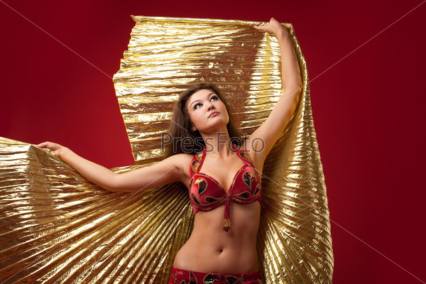 Young girl dance with gold wing on red