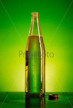 green soda bottle and ice cubes, green and yellow background