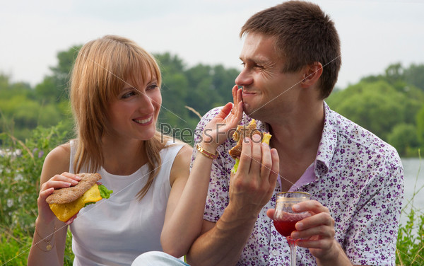 Young happy couple eating together outdoors