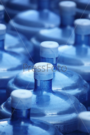 Big blue reusable water bottles background. Shallow DOF.