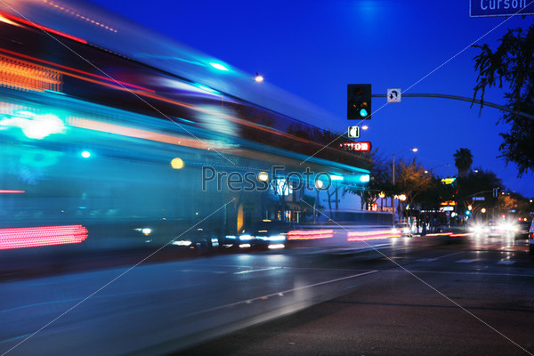 Размытые огни вечерней улицы, по которой едет автобус, Санта Моника, США