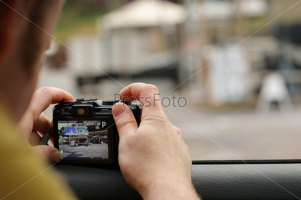 Man shooting with compact point and shoot camera. Shallow DOF.