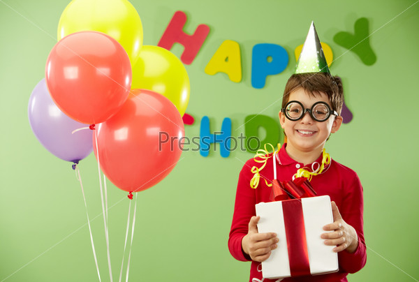 Portrait of happy lad in funny eyeglasses on birthday party with giftbox