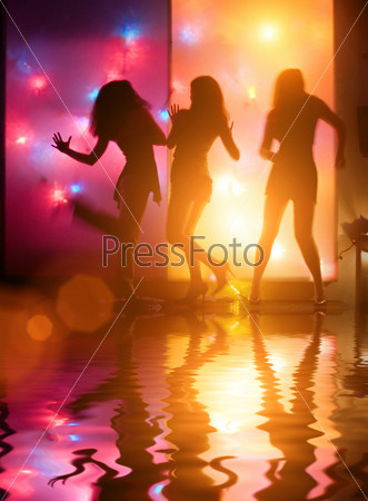 Dancing girls silhouettes in front of colorful disco lights