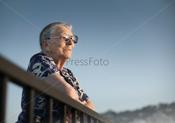 Senior woman looking forward over blue sky.