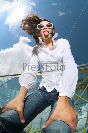 Fun wide angle portrait of young woman in blue jeans