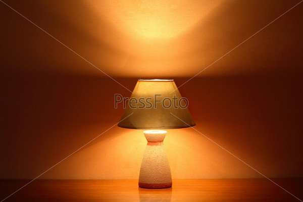 Nice luminous desk lamp on ginger background with copy space
