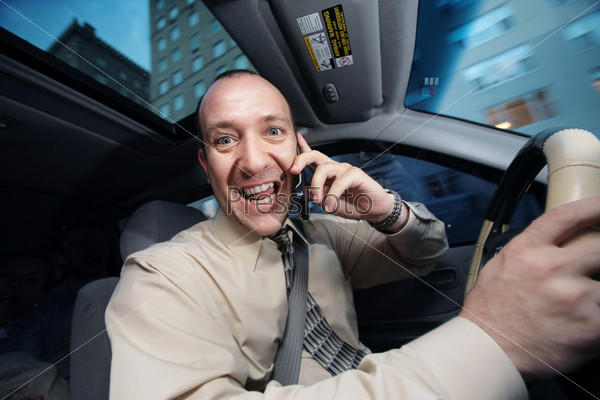 Businessman driving in car and talking on cell phone