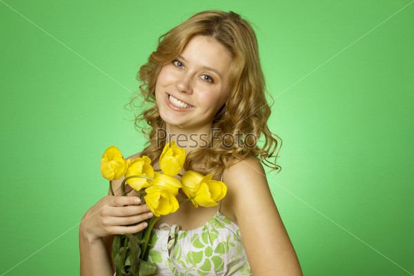 HappyClose up on a green background Happy young woman hugging a yellow tulip. Young Woman Hugging Flower