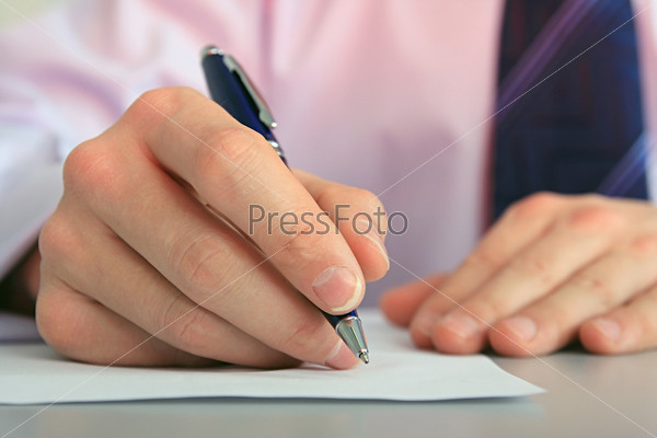 Hands of businessman with a pen and paper.