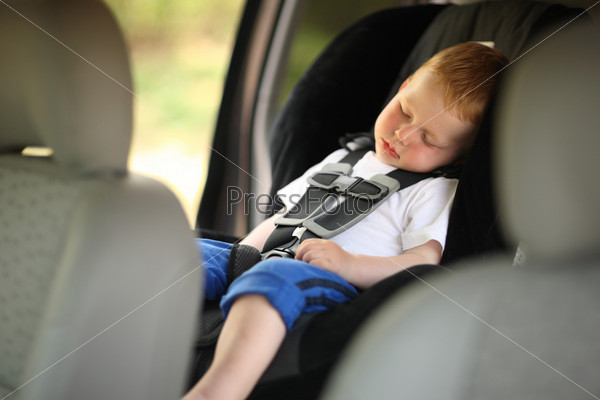 Boy sleeping in child car seat. Shallow DOF.