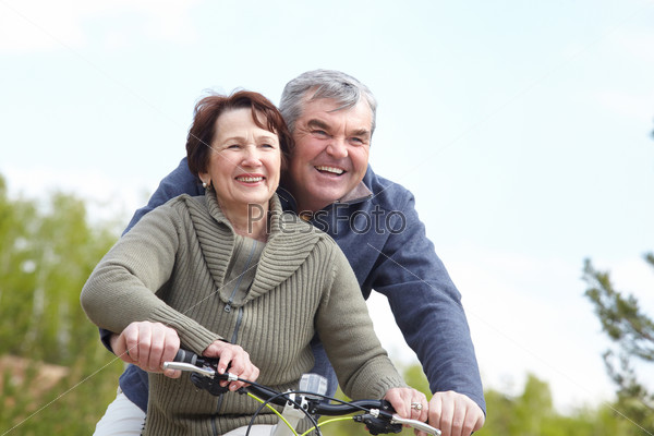 Portrait of happy mature couple on bicycle together