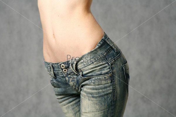 belly of beautiful young woman in jeans studio shot