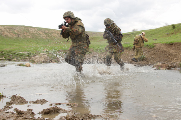 Soldiers running across the water, stock photo