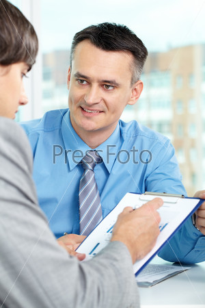 Handsome manager looking at business partner during conversation