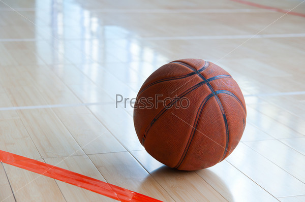 Баскетбольный мяч на деревянном полу в спортзале