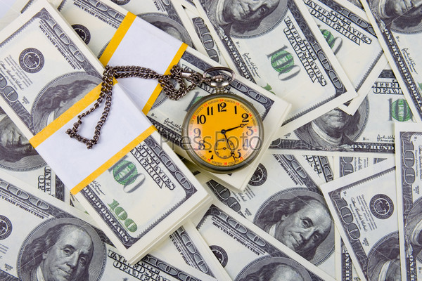 Pocket watch on a stack of dollars, reflecting time and money