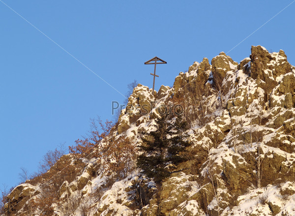 Зимний пейзаж с деревянным крестом на скале